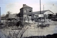 picture of the garage of J. Heath & Co, this one showing the water flowing off of the road