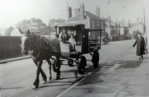 A Co-op milk float passes the Cricket Ground on Station Road.