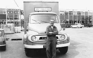 George Burrows and his Vic Hallam van in front of new office block, c.1960.